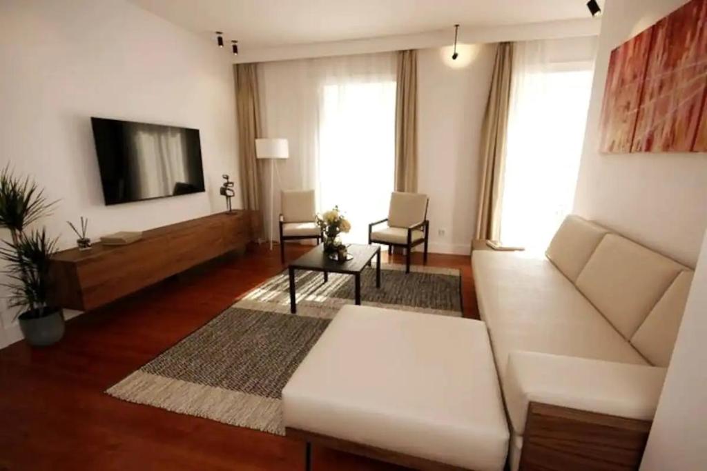 里斯本Timeless Ambassador -Belém的客厅配有白色沙发和平面电视。