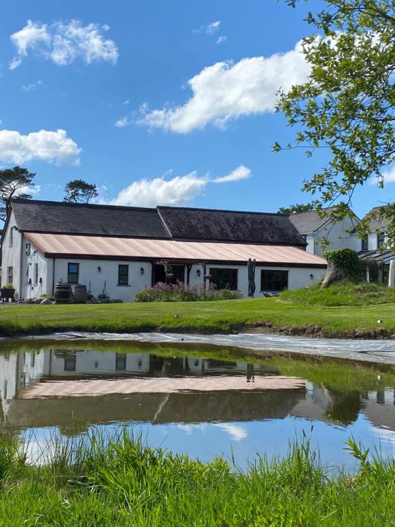 WhitlandJabajak Vineyard Restaurant & Rooms的前面有池塘的建筑