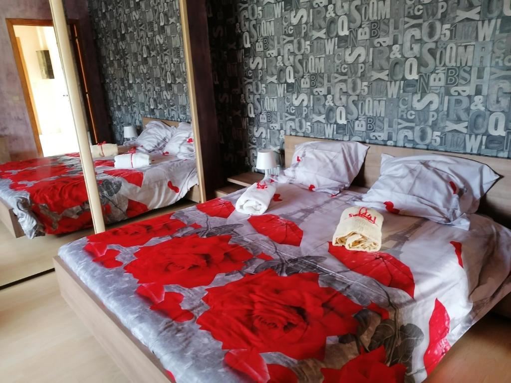 希尼Sweet Home En Gaume的一间卧室配有两张红色玫瑰床。