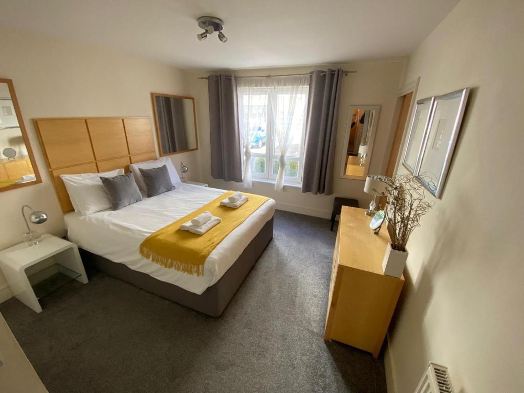 爱丁堡Hopetoun Apartment with free parking的一间卧室设有一张大床和一个窗户。