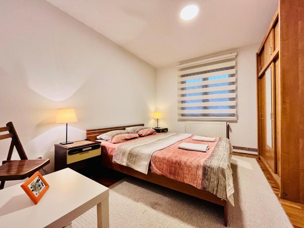 乌日策维克特瑞加公寓的一间卧室配有一张床、一张桌子和一个窗户。