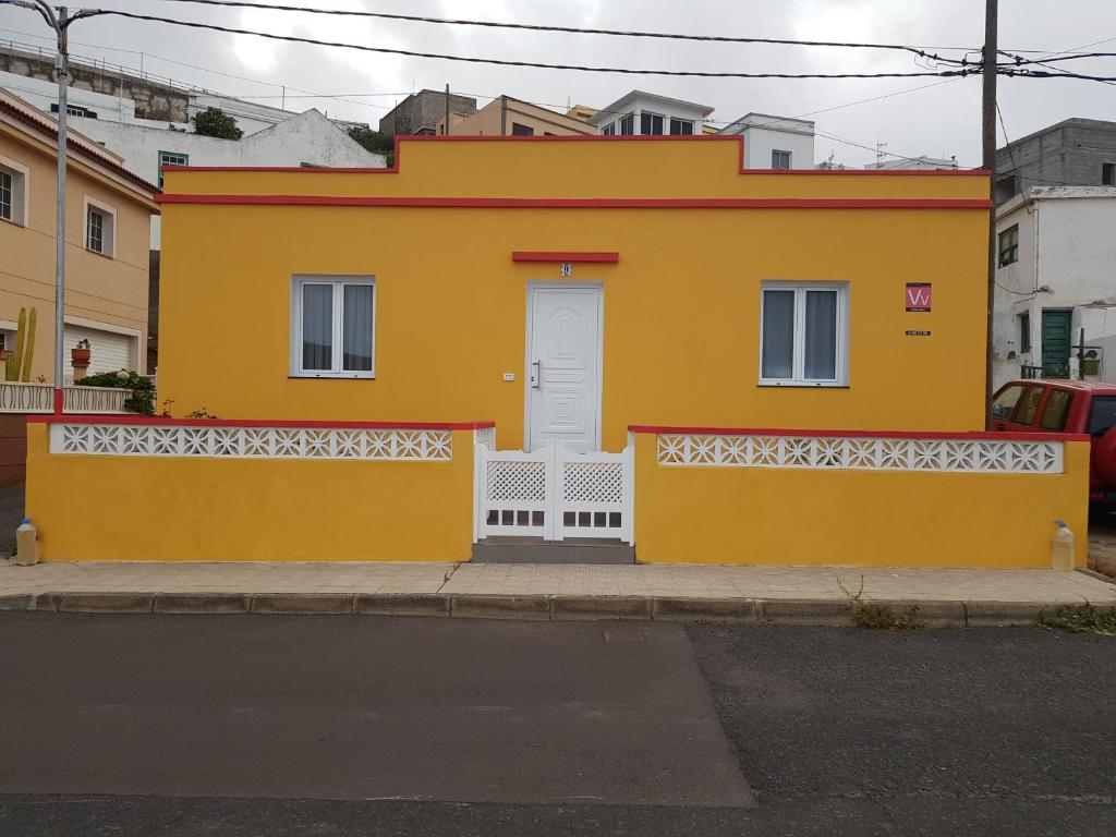 巴尔韦尔德Vv CASA JULIA的街上有一扇白色门的黄色房子