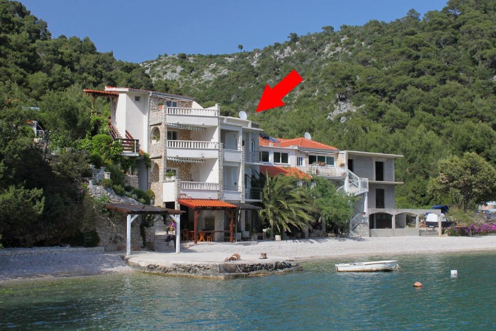 博格莫耶Seaside secluded apartments Cove Smokvina, Hvar - 9501的水岸上一座有红旗的建筑