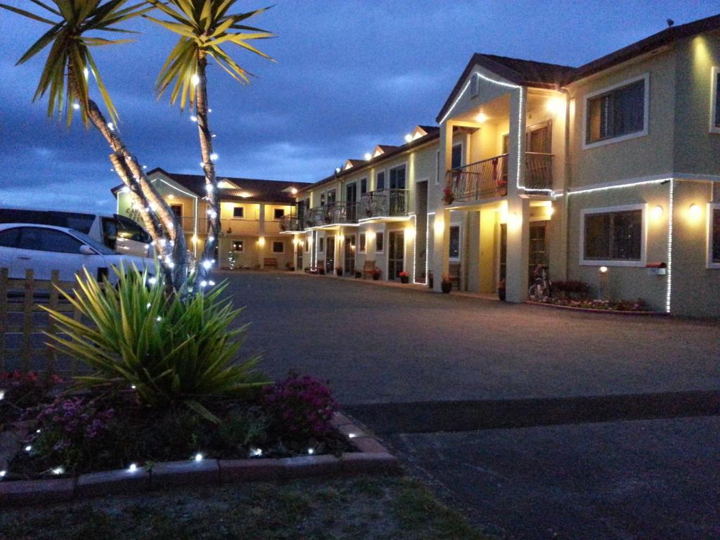 罗托鲁瓦纽卡斯尔汽车旅馆的一座棕榈树建筑和一个停车场