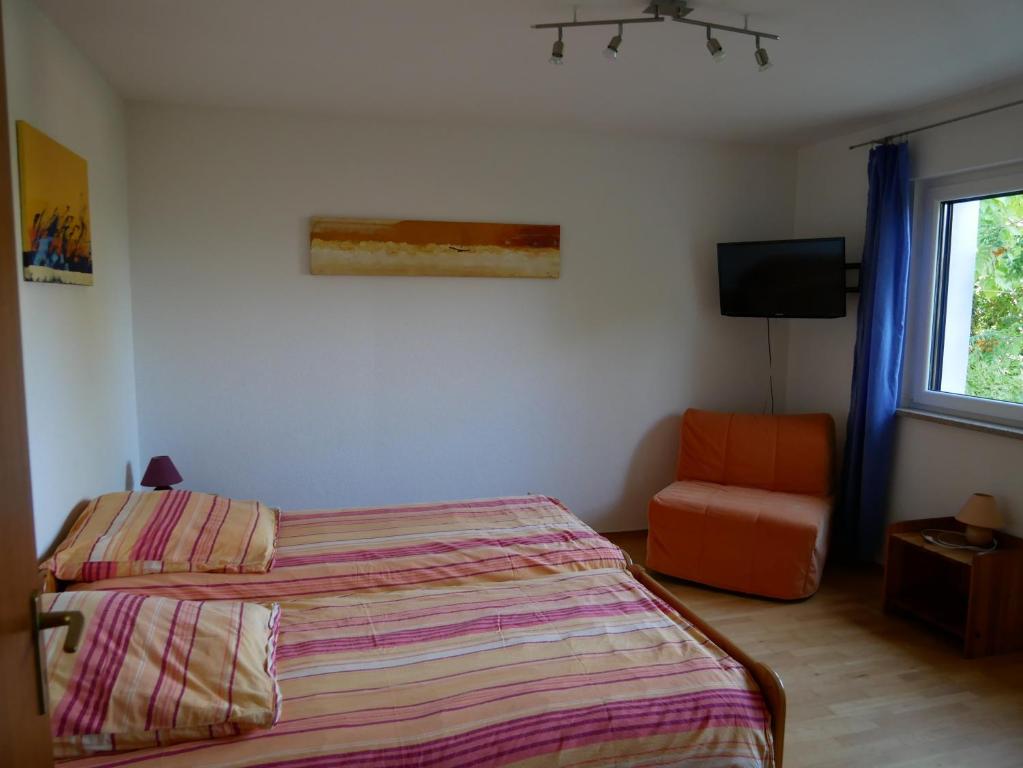 蒂宾根Ferienwohnung Timm的卧室配有床、椅子和窗户。