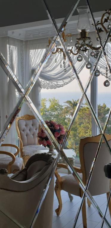 安塔利亚Konyaaltı plajına 10 dakika kral dairesi的客房设有带椅子和吊灯的窗户。