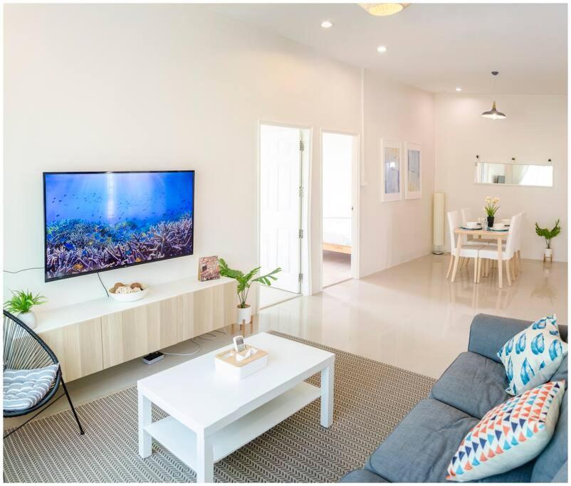 素可泰100sqm 2 bed apartment Sukhothai City的客厅配有沙发和墙上的电视