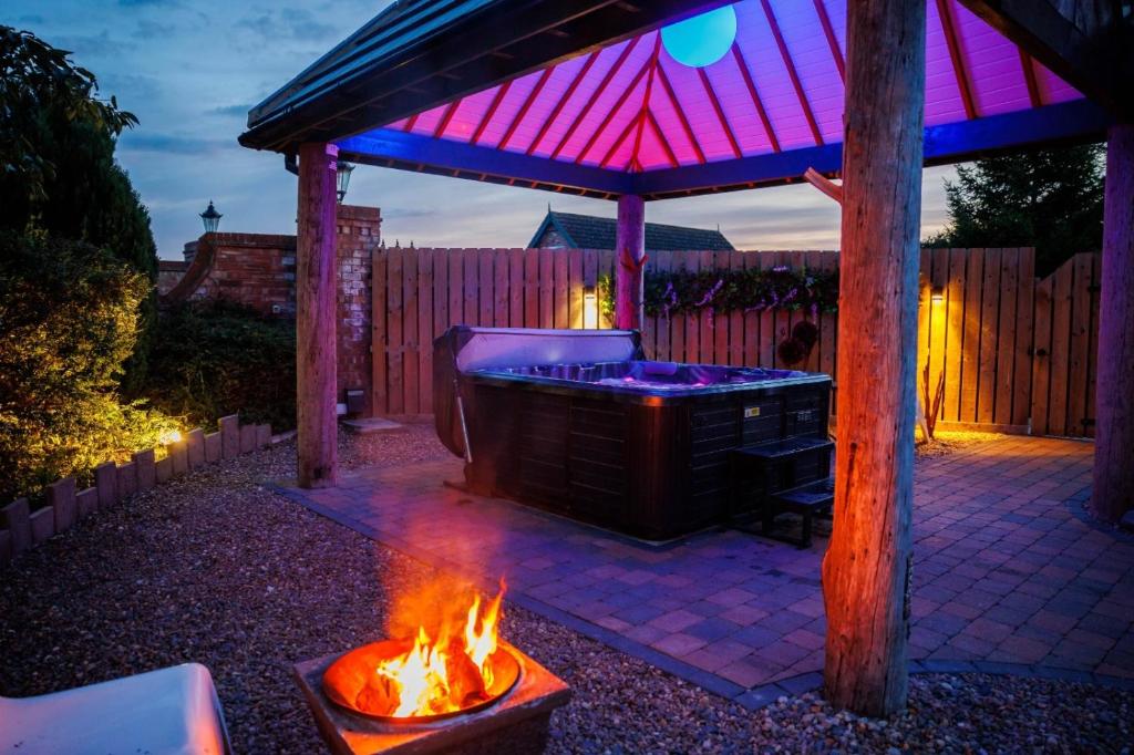 林肯Lincoln Holiday Retreat Lodge with Private Hot Tub的后院的热水浴池,带火坑