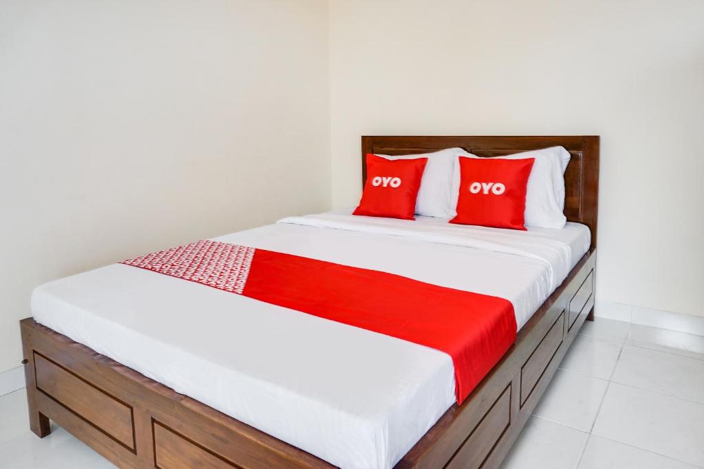 玛琅OYO Life 91569 Omah Wijaya Kusuma Syariah的一间卧室配有红色枕头的床