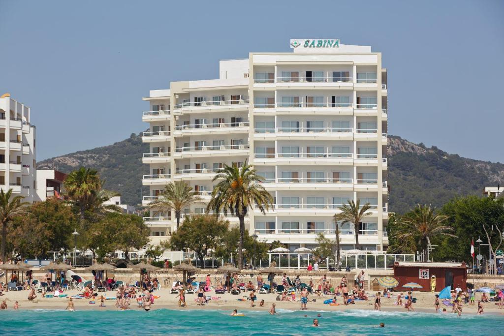 卡拉米洛萨拜娜酒店的一群人坐在酒店前的海滩上