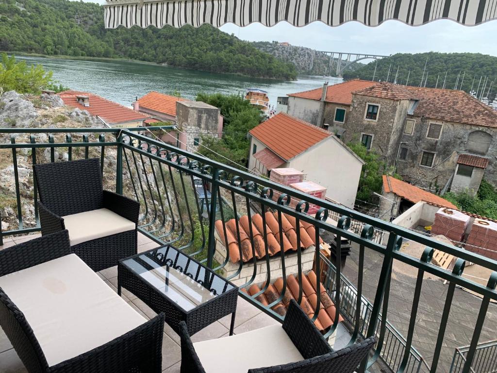 斯克拉丁Family house Scardona - dreams by the river Krka的阳台配有桌椅,享有河流美景。