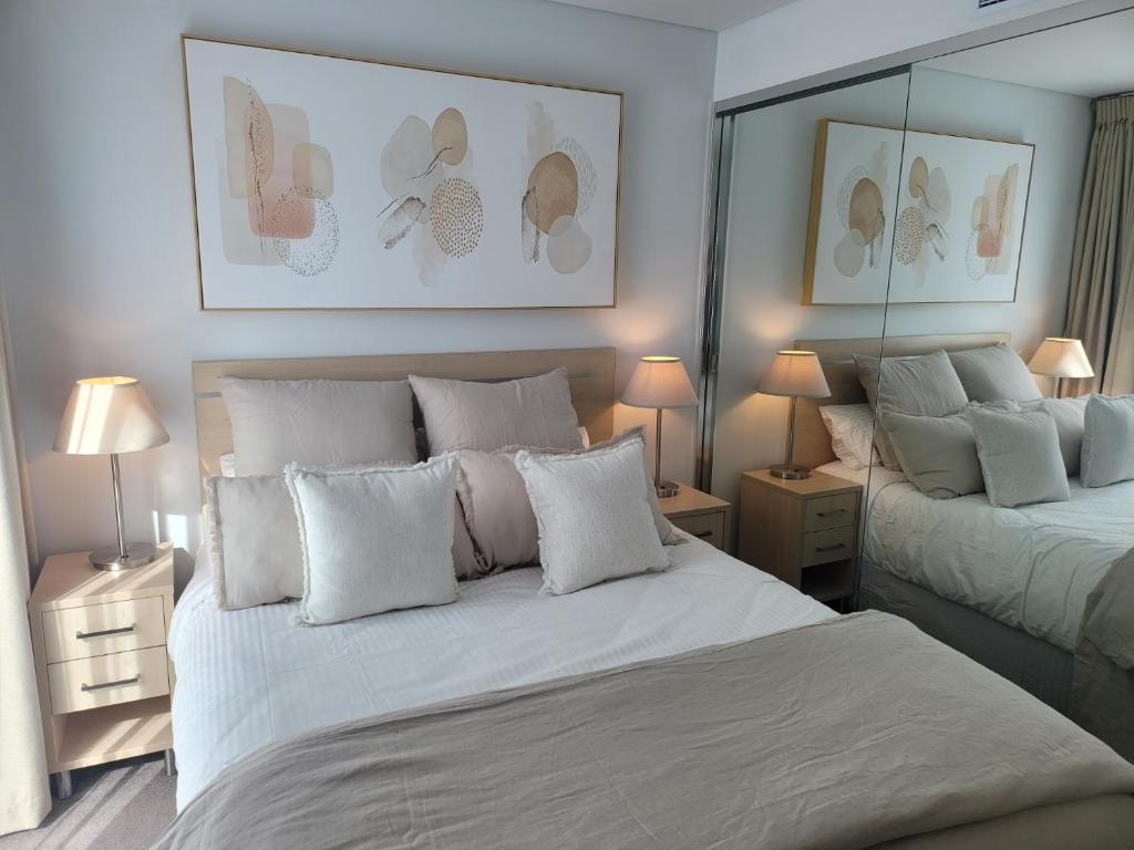 阿德莱德CBD Deluxe Private 2 Bedroom Apartment的一间卧室配有两张带白色枕头的床