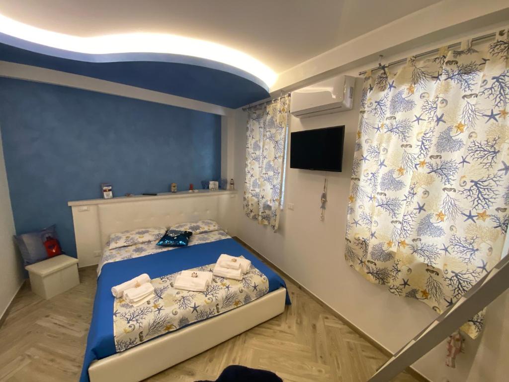 贾迪尼-纳克索斯MarEtna的一间卧室配有一张带蓝色墙壁和窗帘的床