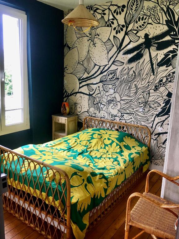 Baillet-en-FranceChambre privée les Clottins dans maison的一间卧室配有一张带花卉壁纸的床