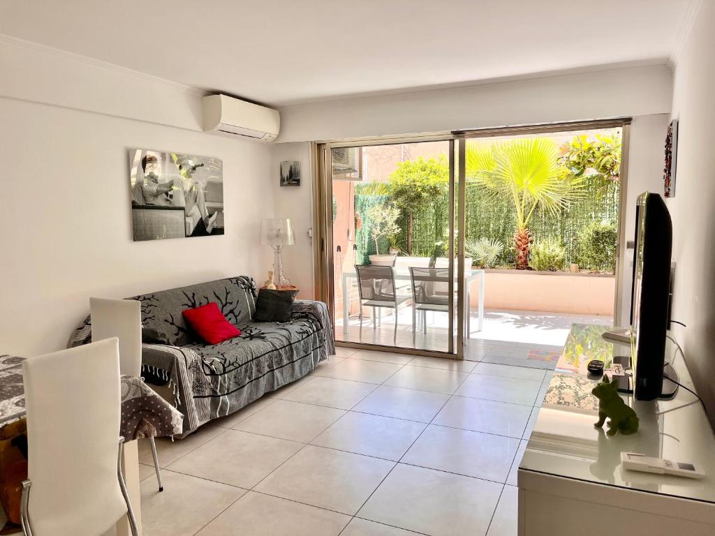 戛纳Apartment Cannes Rico Beach的带沙发和滑动玻璃门的客厅