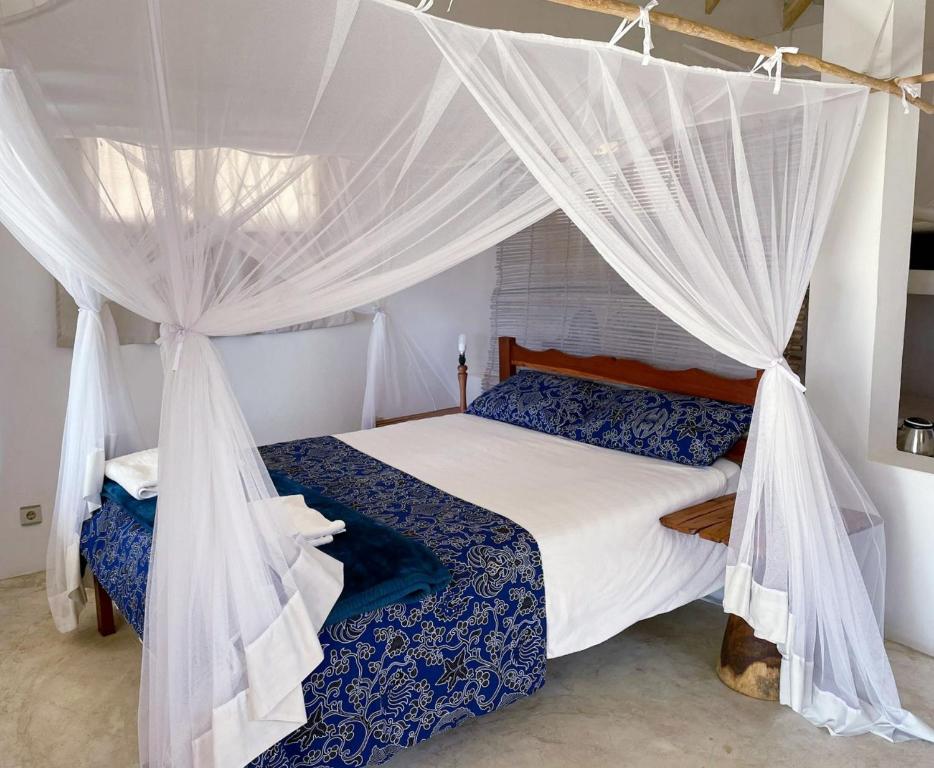 维兰库卢什Baobab Beach Vilanculos的一间卧室配有带蚊帐的床