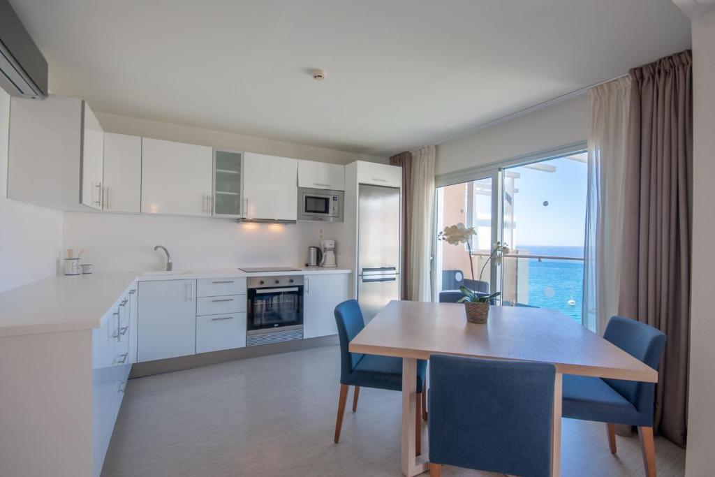 莫甘Superior 2 bedroom penthouse, almost on the beach.的厨房以及带桌椅的用餐室。