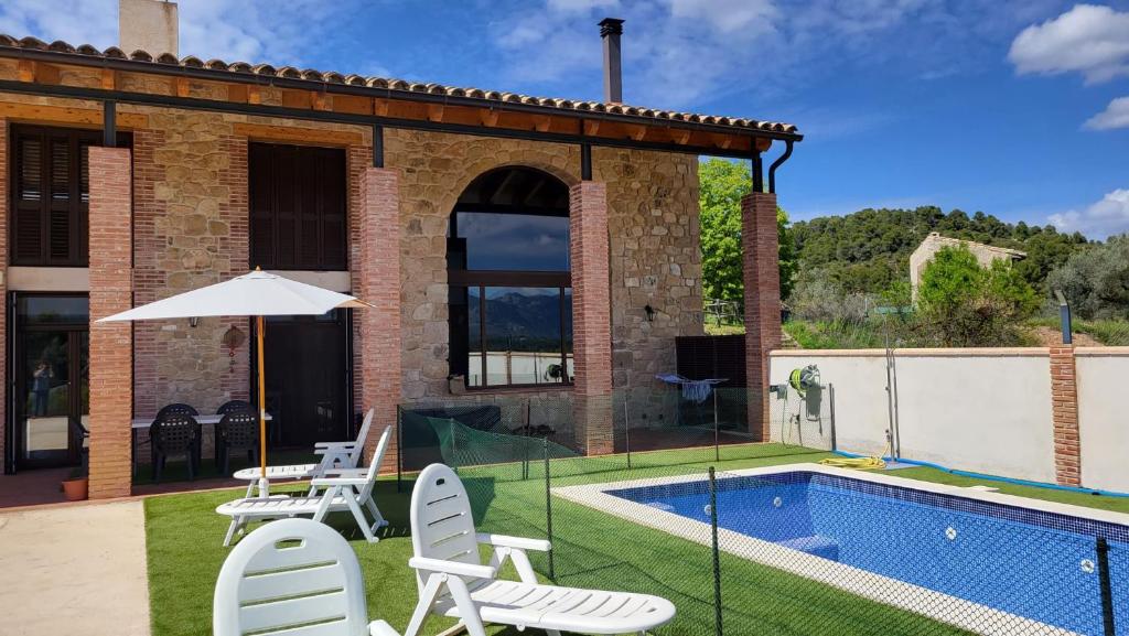 LledóMas De La Font的一座房子,设有游泳池、椅子和遮阳伞
