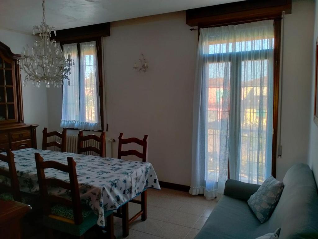 斯嘉德瓦利Casa nel Delta del Po的客厅配有桌子、沙发和窗户。