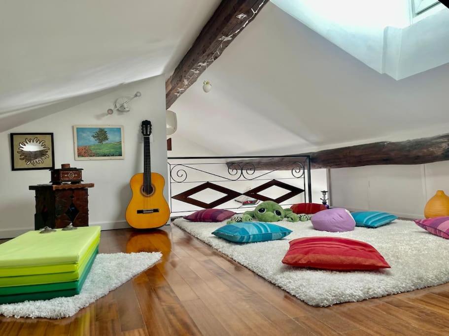 热那亚MOONLIGHT IN BOCCADASSE (cod.Citra:010025-LT-2349)的客房设有三张床、色彩缤纷的枕头和吉他。