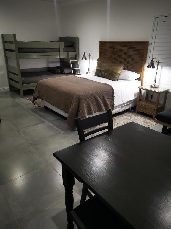 布隆方丹10 Jock Meiring Guesthouse Unit 3的一间卧室配有一张大床和一张桌子