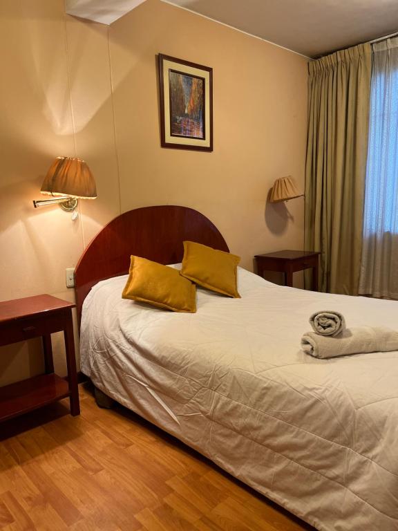 库斯科Hotel Vilandre的一间卧室配有一张带两个黄色枕头的床