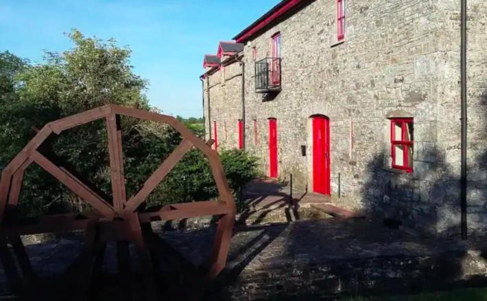 BellanagareThe Old Mill, Kilcorkey, Bellanagare, Castlerea, County Roscommon - West of Ireland的石头建筑,设有红色窗户和木门