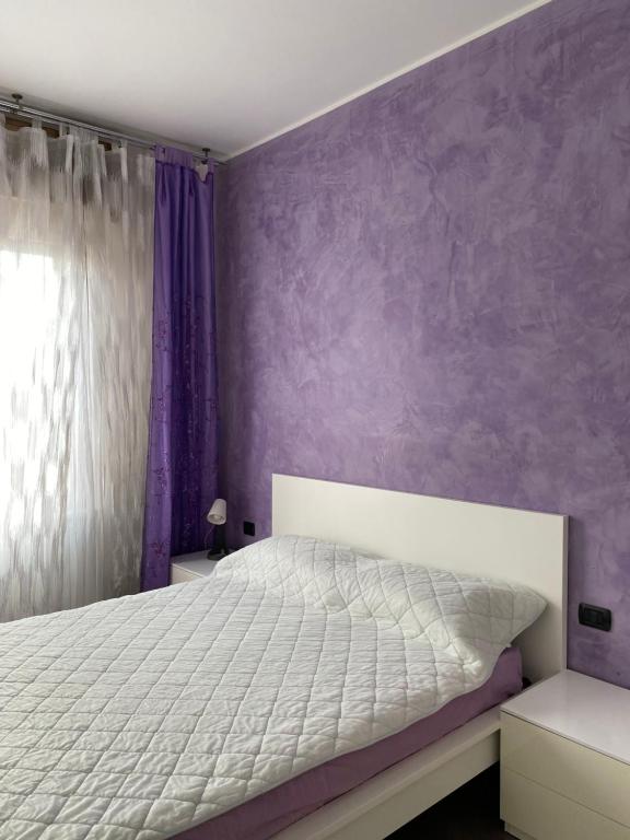 科洛尼奥蒙泽塞Petit place incantevole a due passi da Milano!的卧室配有白色的床和紫色的墙壁