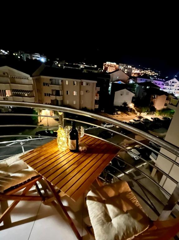 布德瓦Boutique apartman Dora Yung的夜间阳台顶部的木桌