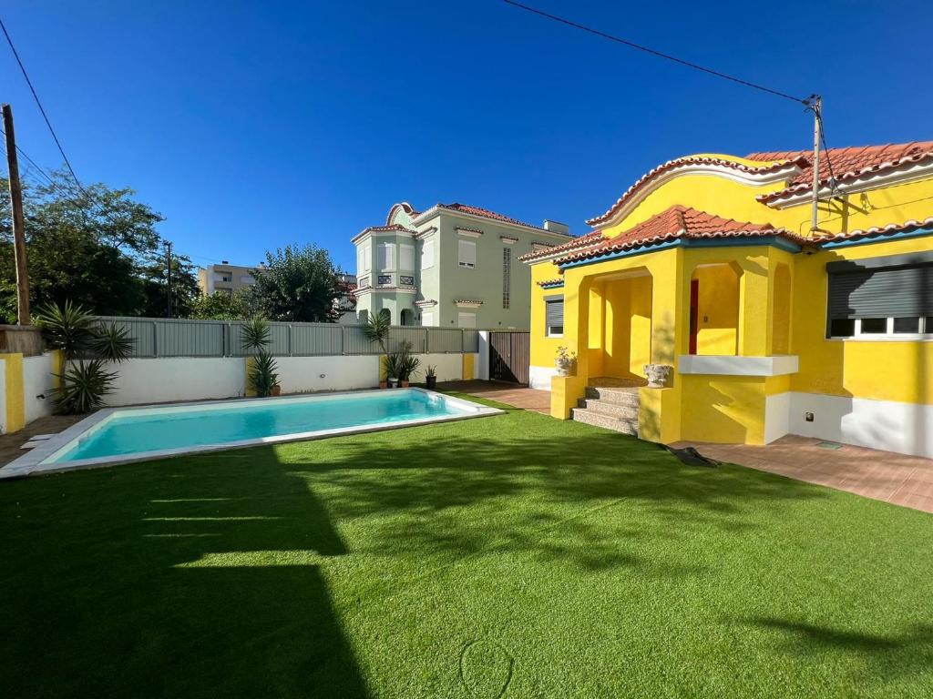 卡帕里卡海岸Kali Vice Surf Villa的一座黄色的房子,在院子里设有游泳池