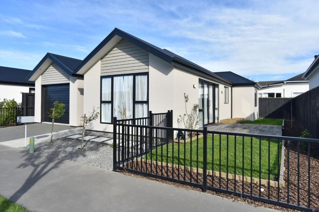 基督城Thomas Townhouse - Christchurch Holiday Homes的 ⁇ 染有黑色栅栏的房子