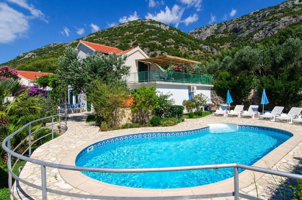 维甘Seaside family friendly house with a swimming pool Viganj, Peljesac - 10253的山前带游泳池的别墅