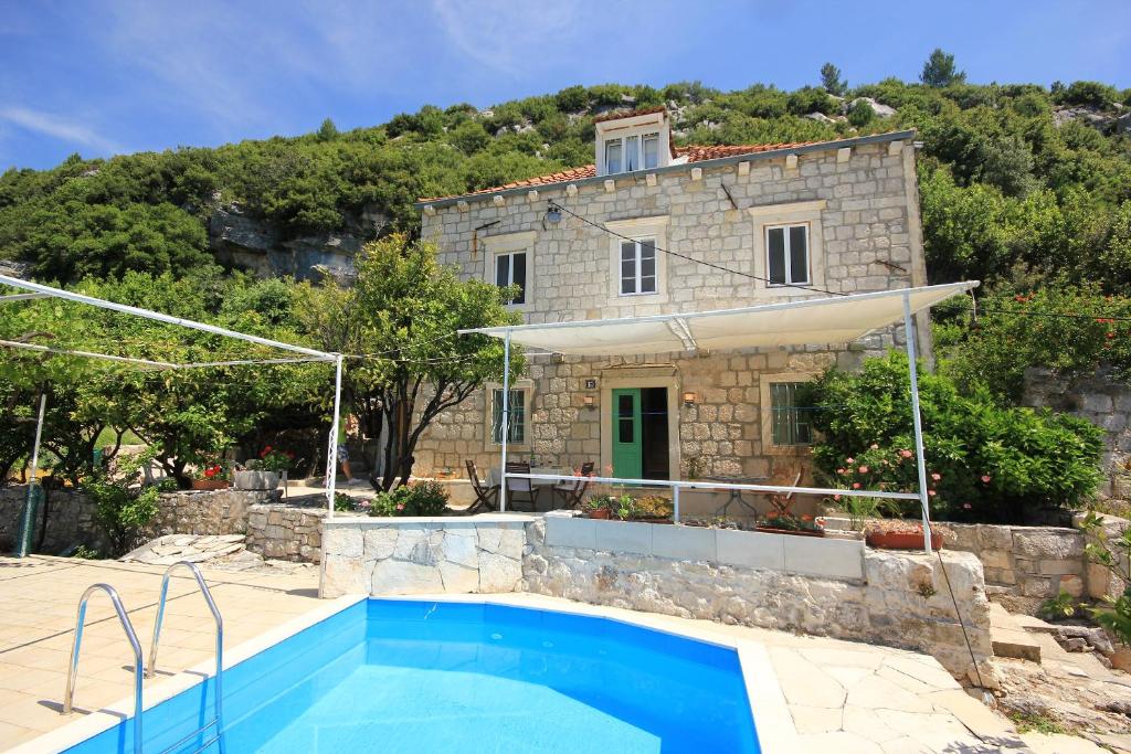 维甘Holiday house with a swimming pool Viganj, Peljesac - 10175的别墅前设有游泳池