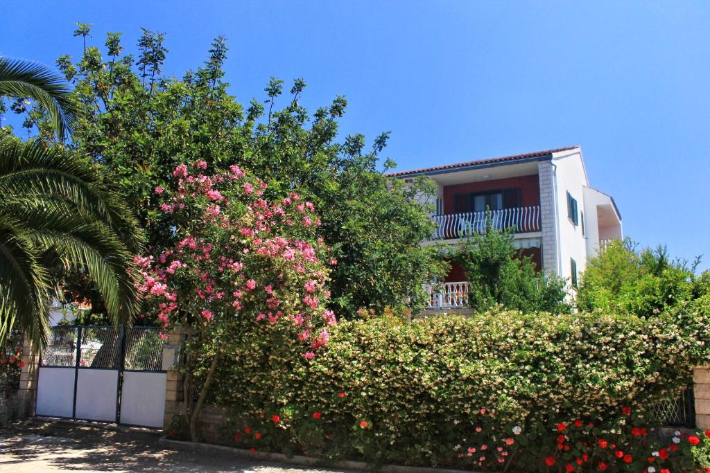 洛维什特Apartments by the sea Loviste, Peljesac - 10182的围栏前有粉红色花的房屋