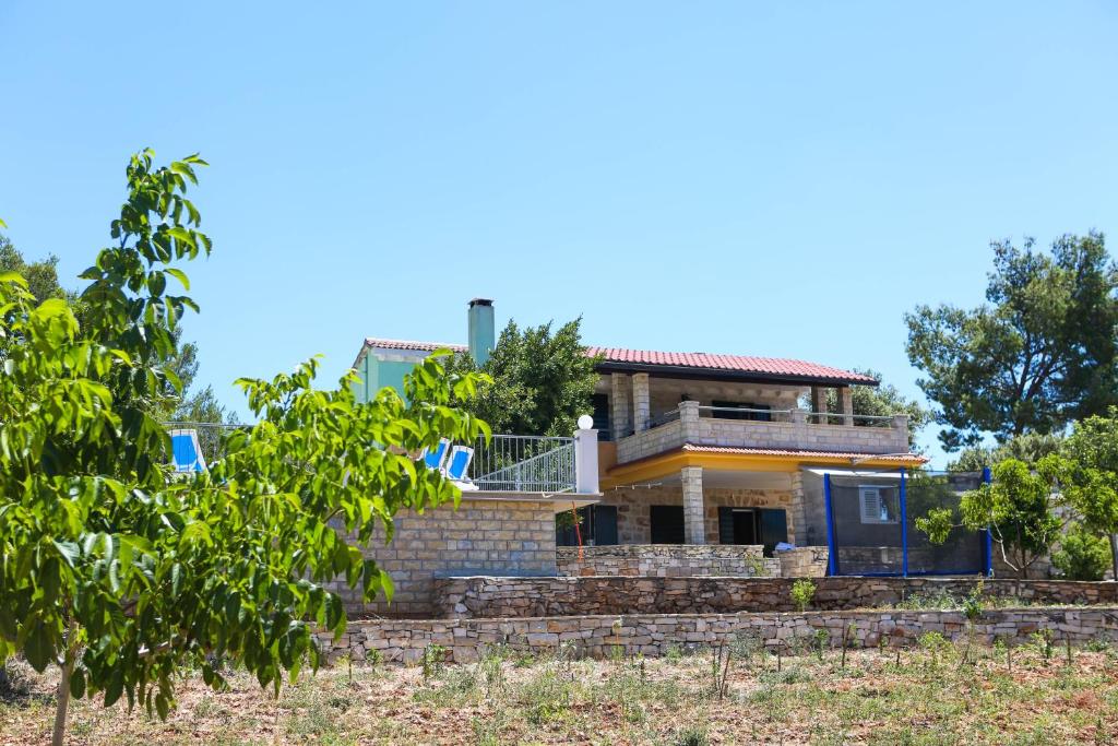 扎瓦拉提卡Family friendly house with a swimming pool Zavalatica, Korcula - 9476的山丘上树木林立的房屋