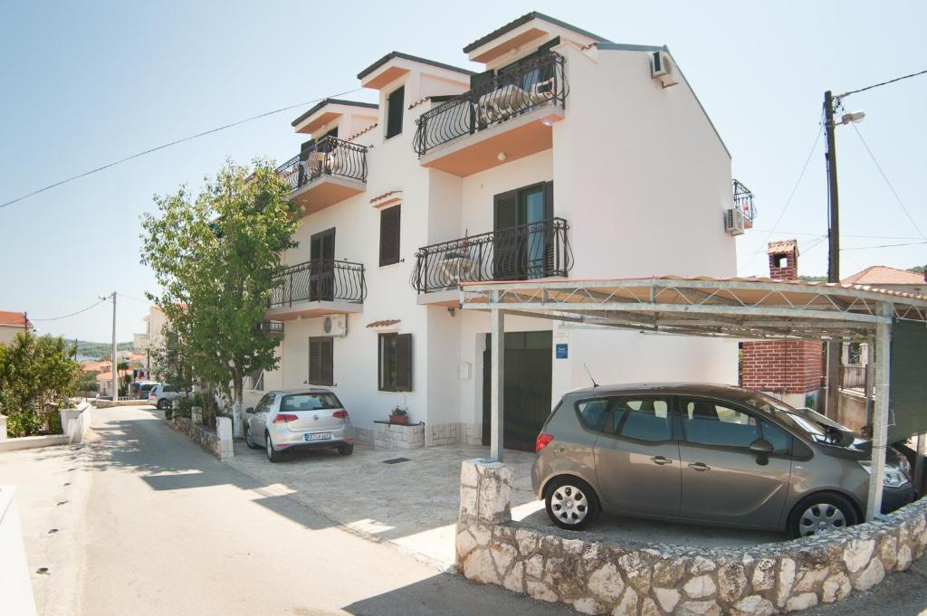 斯拉汀Apartments by the sea Slatine, Ciovo - 12176的停在大楼前的小汽车