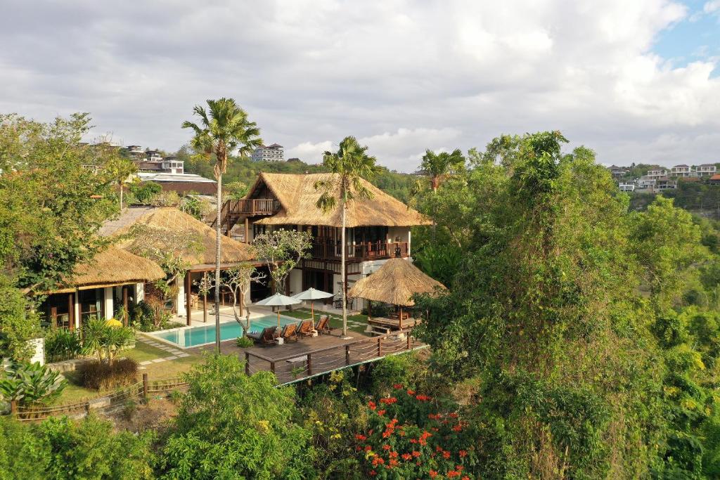 金巴兰Jimbaran Beach Villas by Nakula的享有带游泳池和树木的房屋的空中景致