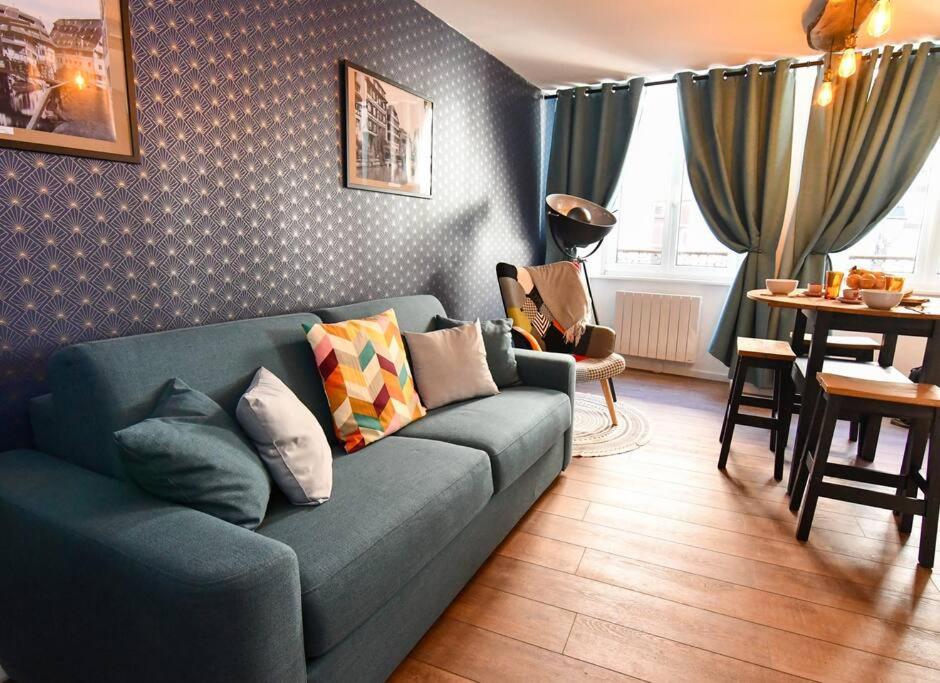 塞莱斯塔Au Fil du Temps的客厅配有蓝色的沙发和桌子