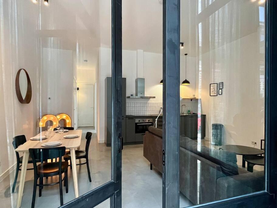 鹿特丹Trendy 2 Bedroom Serviced Apartment的厨房以及带桌椅的用餐室。
