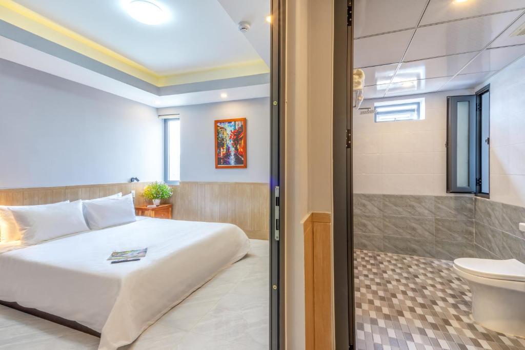 岘港Mina Home Đà Nẵng的一间卧室设有一张床、淋浴和卫生间
