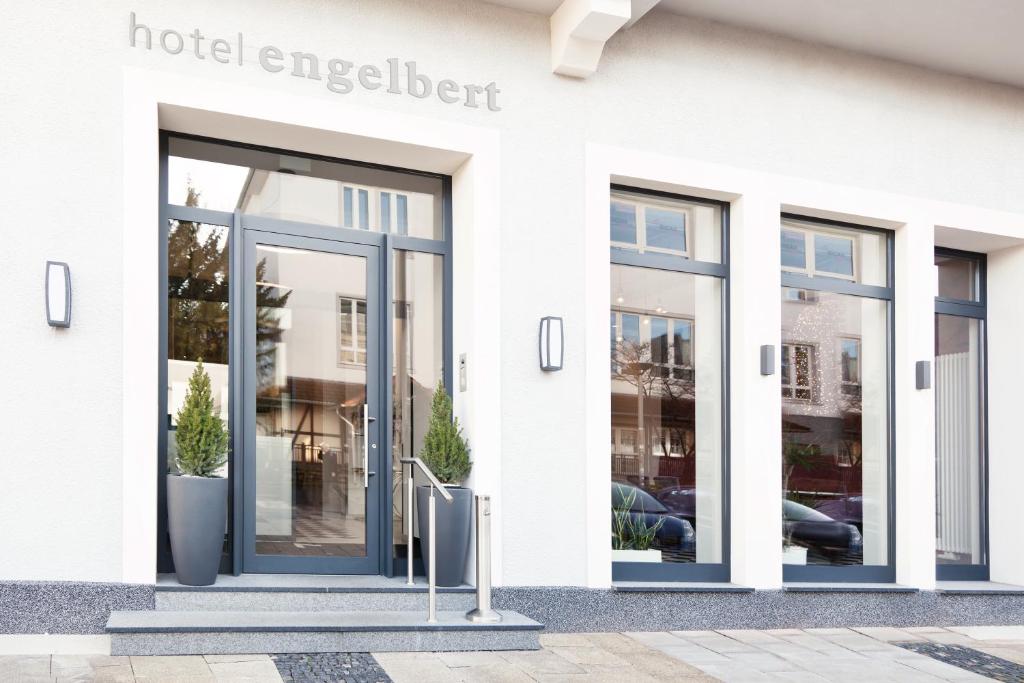 伊瑟隆恩格尔贝特酒店的一座白色的建筑,有门通往酒店精力充沛的人士