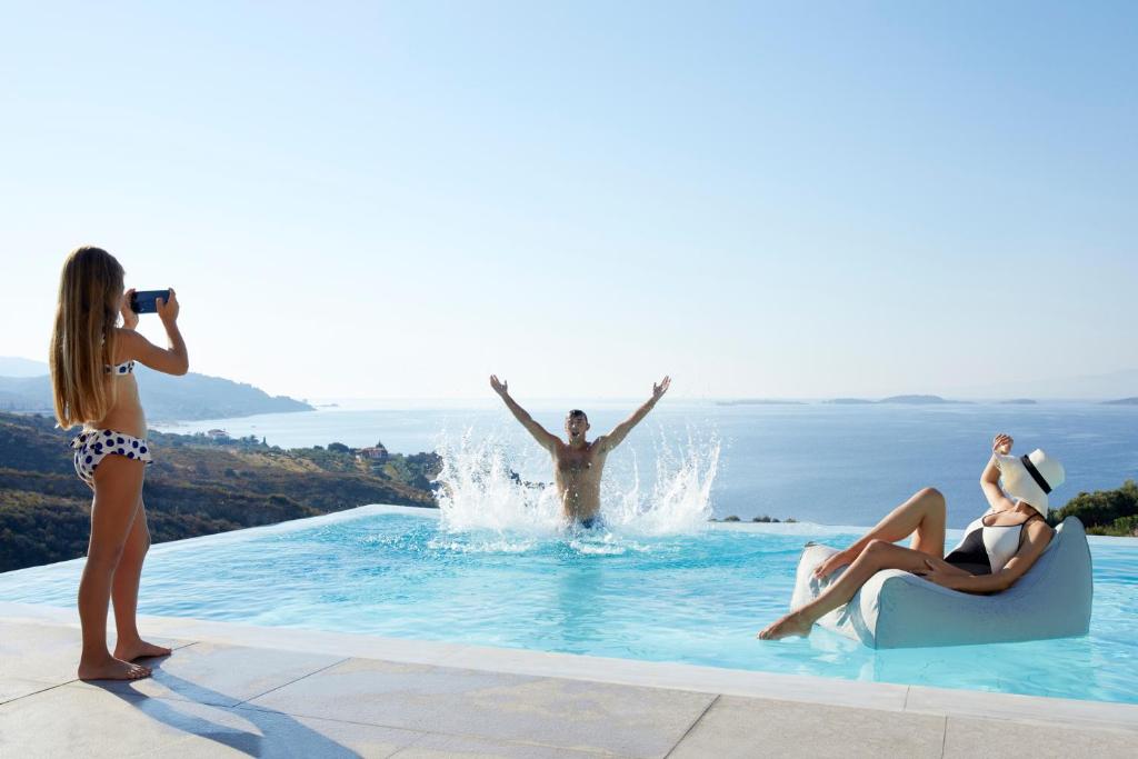 欧拉努波利斯鹰之宫酒店的游泳池里一个女人拍男人的照片