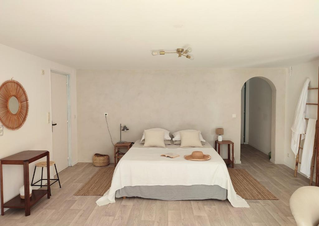 乌瑞基尼Maison Caiada的一间白色的卧室,配有一张带帽子的床