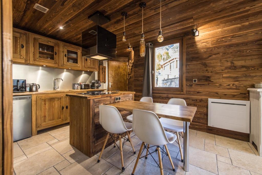兰斯勒维拉德Norberts Place的厨房设有木墙和木桌及椅子
