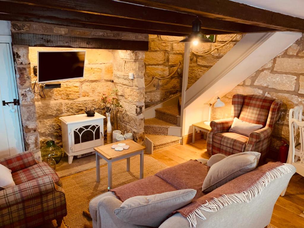 惠特比Cosy 400 yr old Cottage, Flowergate, Whitby的带沙发和壁炉的客厅