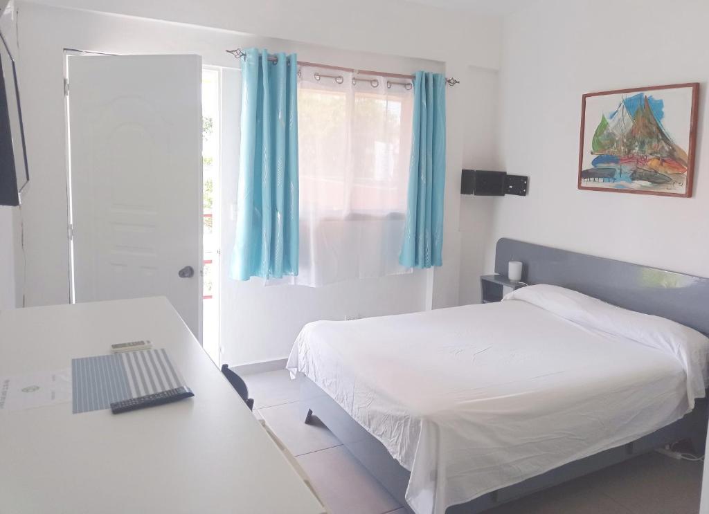 博卡奇卡卡萨可可酒店的一间卧室配有一张床和一张带笔记本电脑的书桌