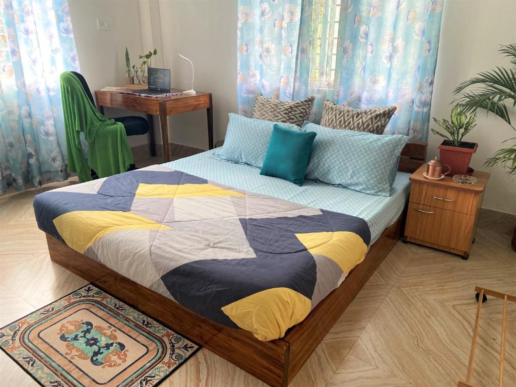 西里古里Bhuman Homestay的一间卧室,床上有五颜六色的被子
