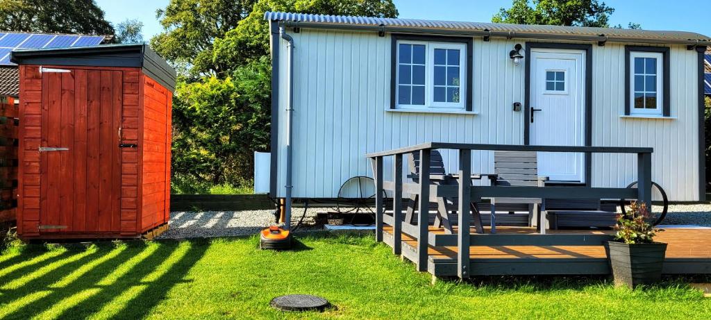 巴尔马卡拉Cozy Shepherd hut 20 by 7 feet with boxed in high double bed的后院,带棚子,甲板和房子