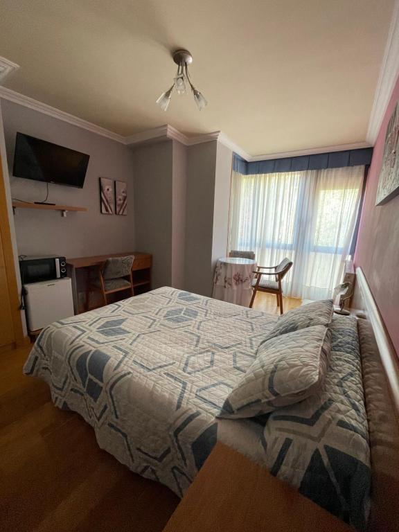 布尔戈斯圣地亚哥2号旅馆的一间卧室配有一张床、一张桌子和一个窗户。