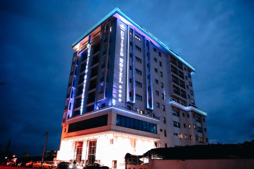 雅温得UNITED HOTEL INTERNATIONAL的一座高大的建筑,上面有蓝色的灯光